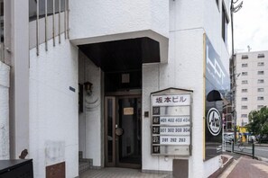 A building entrance with a sign indicating apartment numbers 401-404 and 201-203. - Kaike shibaura (Tokyo)