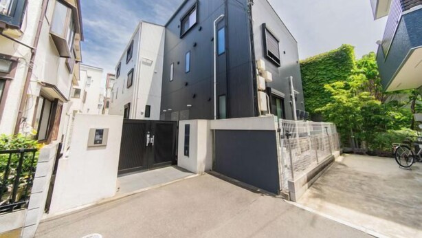 A modern residential building with a gated entrance, a concrete driveway, and a bicycle parked outside. - 10min on foot from Hirai Station. 11min by train to Akihabara Station. (Tokyo)