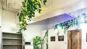 Un salón de conferencias con una mesa de madera, sillas negras, una pizarra blanca y plantas verdes.