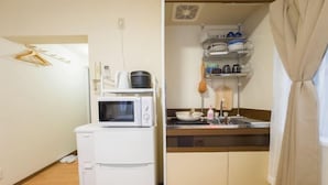 Una kitchenette compacta con microondas, un refrigerador pequeño y un lavamanos con cubierta de madera.