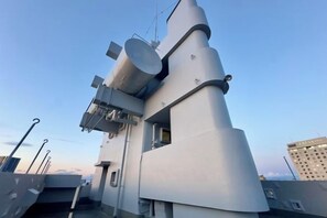 A ship's deck with a large gun turret, radar equipment, and a bridge structure. - Oumekaku (Tokyo)