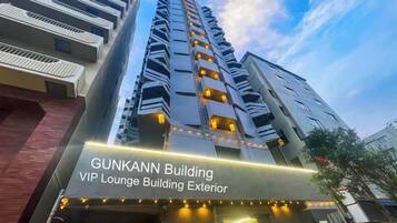 The exterior of the Gunkann Building, featuring a modern architectural design with multiple balconies and a prominent entrance.