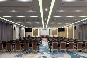 A conference room with rows of chairs, a large screen, and a carpeted floor. - Hotel Anda (Malabo)