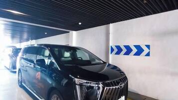 Un SUV negro estacionado en un estacionamiento con flechas indicativas en la pared.