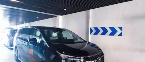 A black SUV parked in a parking garage with directional arrows on the wall.