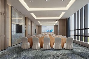 A conference room with a long table, chairs, and a large screen. - Hotel Anda (Malabo)