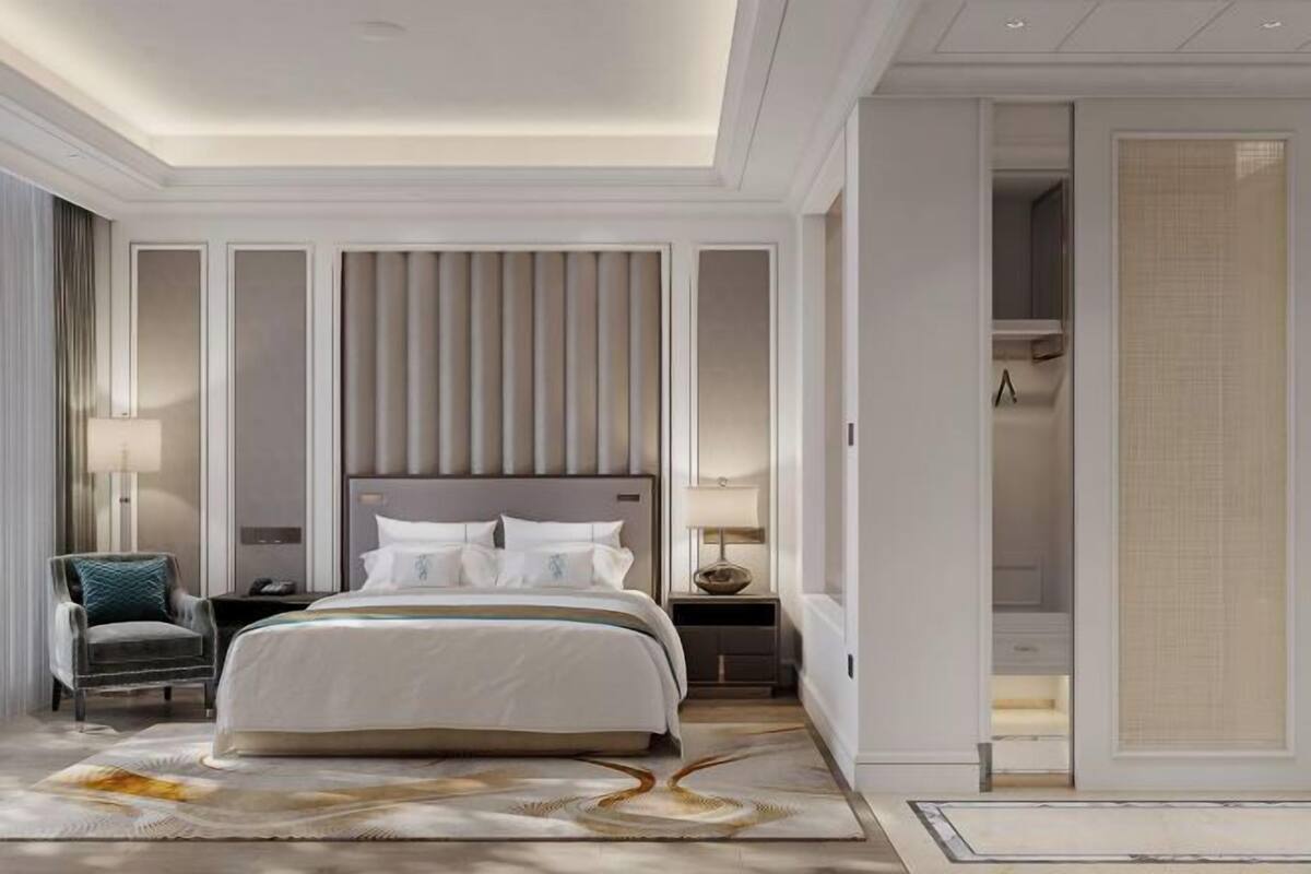 Une chambre moderne avec un grand lit, des tables de chevet, un fauteuil et un dressing.