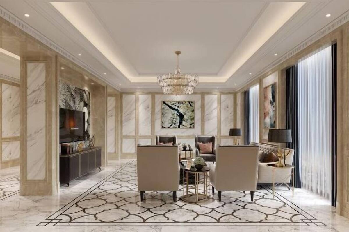 Un hall d’hôtel luxueux avec des murs en marbre, un lustre, un espace repas avec des chaises et des œuvres d’art accrochées aux murs.