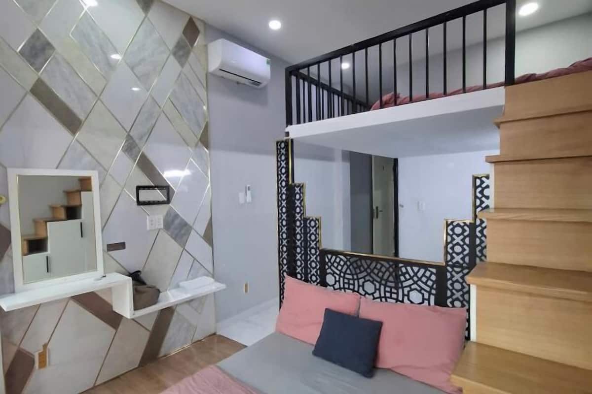 A bedroom with a bunk bed, a mirror, a shelf, and a patterned wall.