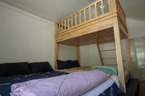 A bunk bed with a wooden frame and a lower single bed. - The Aura Pranburi (Pran Buri)