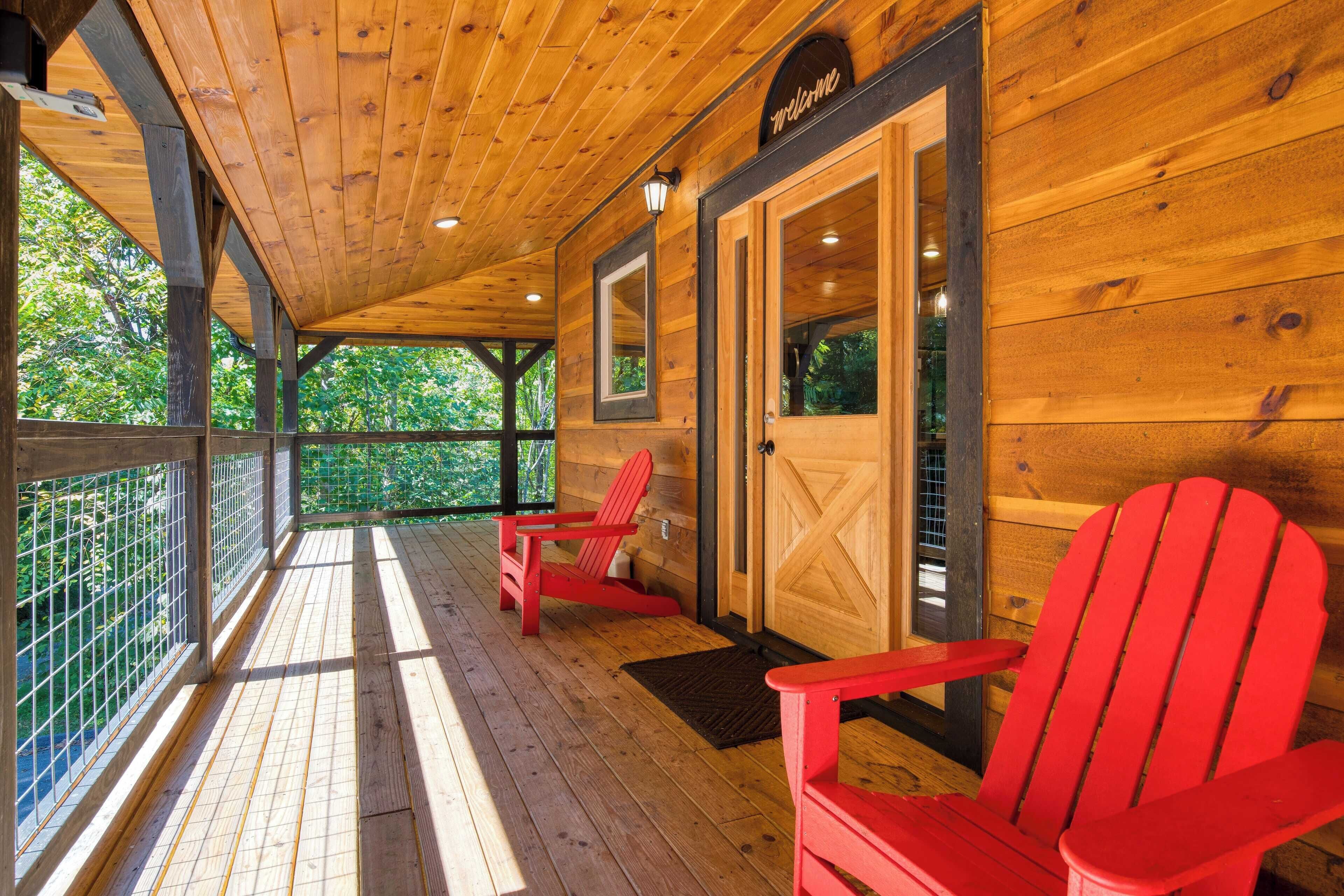A wooden cabin with a porch, two red Adirondack chairs, and a 'Welcome' sign.