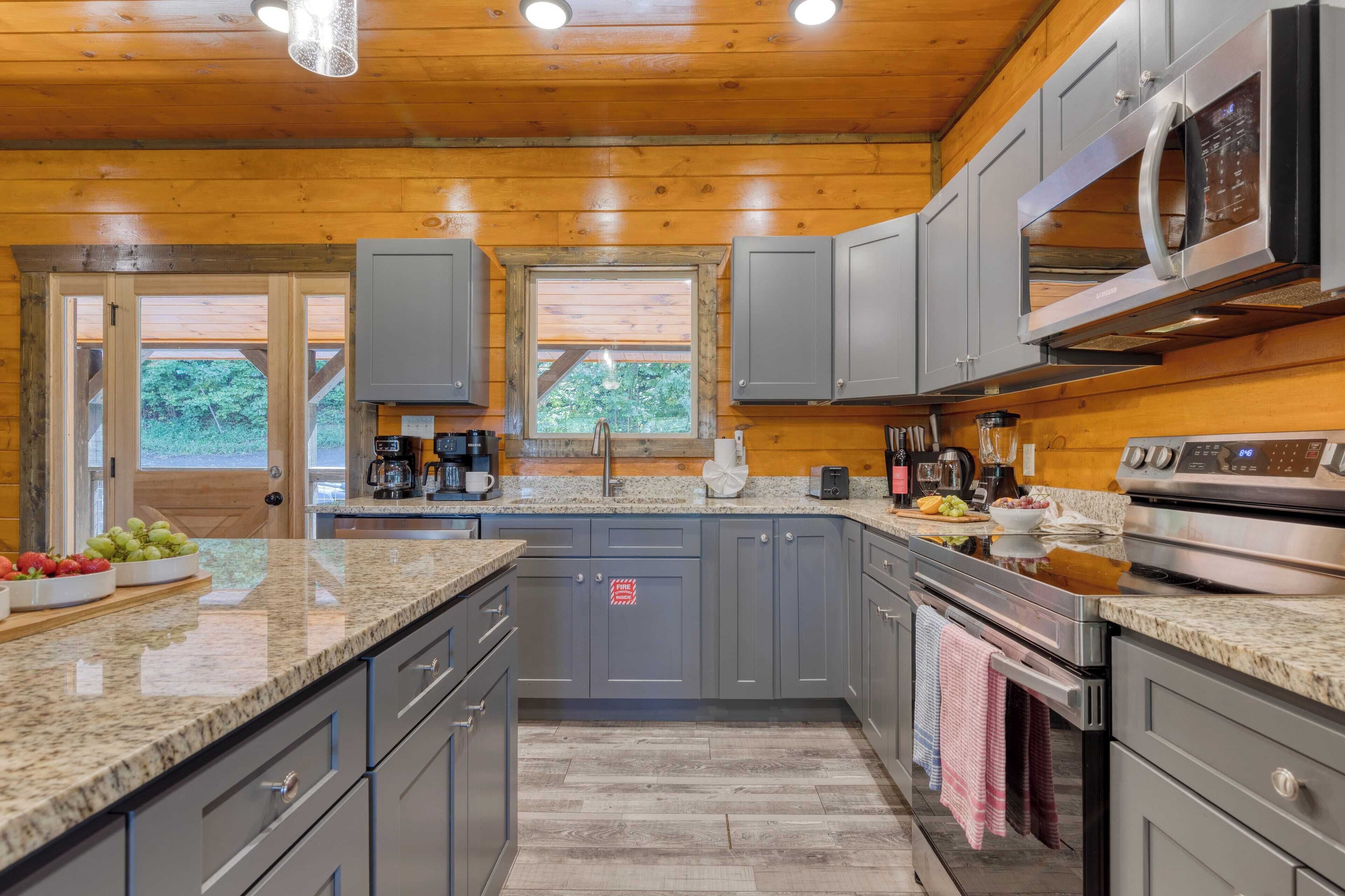 A modern kitchen with granite countertops, stainless steel appliances, and wooden paneling.