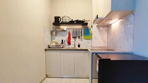A compact kitchen with a built-in oven, a sink, and a countertop with a kettle and utensils. - JQ Angel (Little Angel B&B) New/CitySeaview/LV29/Netflix/6pax (Kota Kinabalu)