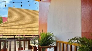 A covered outdoor area with a wooden bench, potted plants, and string lights. - KK Hotel Pakse (Pakse)