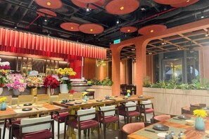 A restaurant interior with tables, chairs, and a variety of flowers. - Vinhomes Chic Apartment - Ho Chi Minh (Ho Chi Minh City)