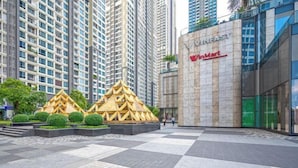 A commercial building with a large sign for WinMart and a distinctive yellow geometric structure in the foreground. - Vinhomes Chic Apartment - Ho Chi Minh (Ho Chi Minh City)