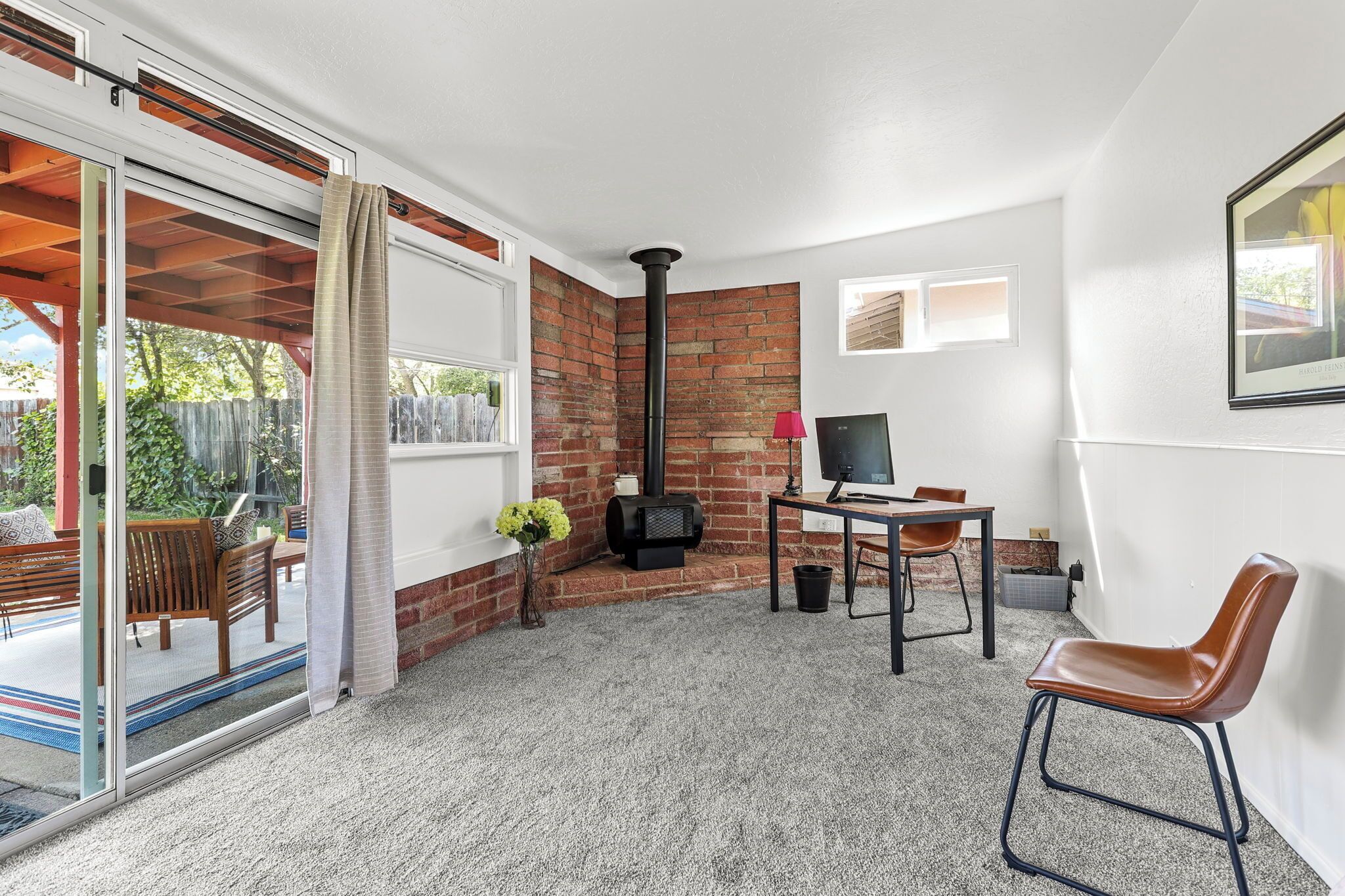 A room with a fireplace, a TV, a table, and a chair.