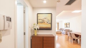 Une chambre d’hôtel moderne avec un meuble en bois, un tableau au mur et un coin repas comprenant une table et des chaises.