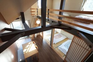 A multi-level room with bunk beds, a desk, and a window. - Life house (Osaka)