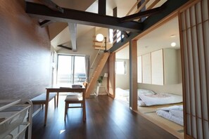 A room with a wooden floor, a bed, a desk, and a chair. - Life house (Osaka)