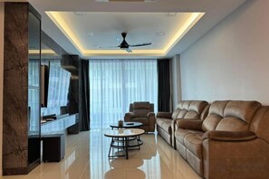A modern living room with a sofa, armchair, and coffee table. - Sri Indah Luxury HomeStay (Sandakan)