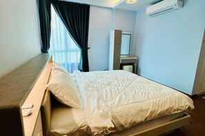Une chambre d’hôtel équipée d’un lit, d’une table de chevet, d’un miroir et d’un appareil de climatisation.