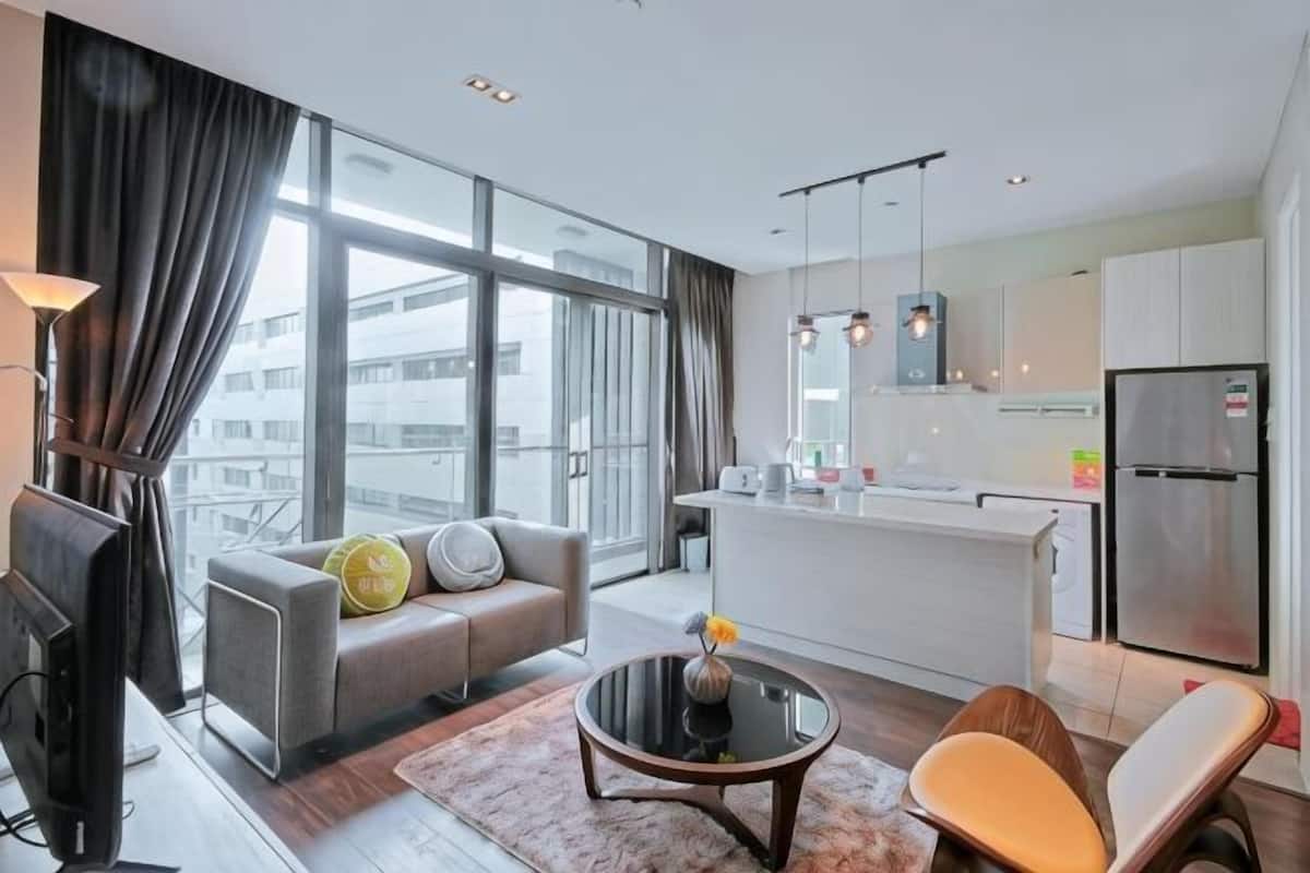 A modern living room with a sofa, a coffee table, and a TV.