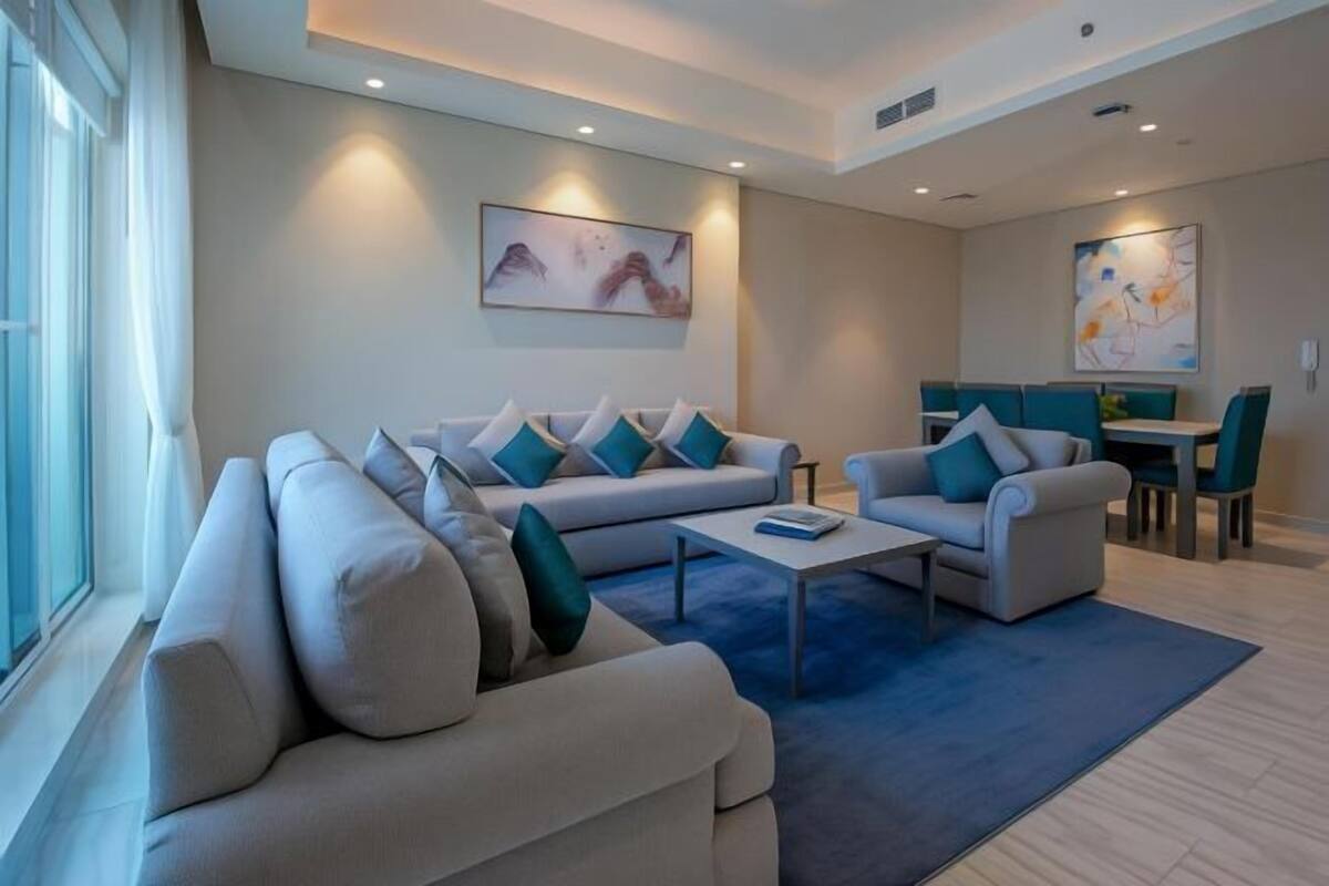 Una sala de estar moderna con un conjunto de sofá, una mesa de centro y un comedor con sillas y una mesa.
