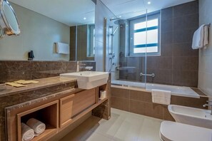 Ein modernes Badezimmer mit einem Doppelwaschbecken, einer Badewanne, einer Dusche und einem WC.