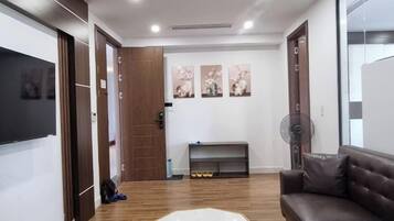 A modern living room with a wooden floor, a white coffee table, a brown sofa, and a fireplace.
