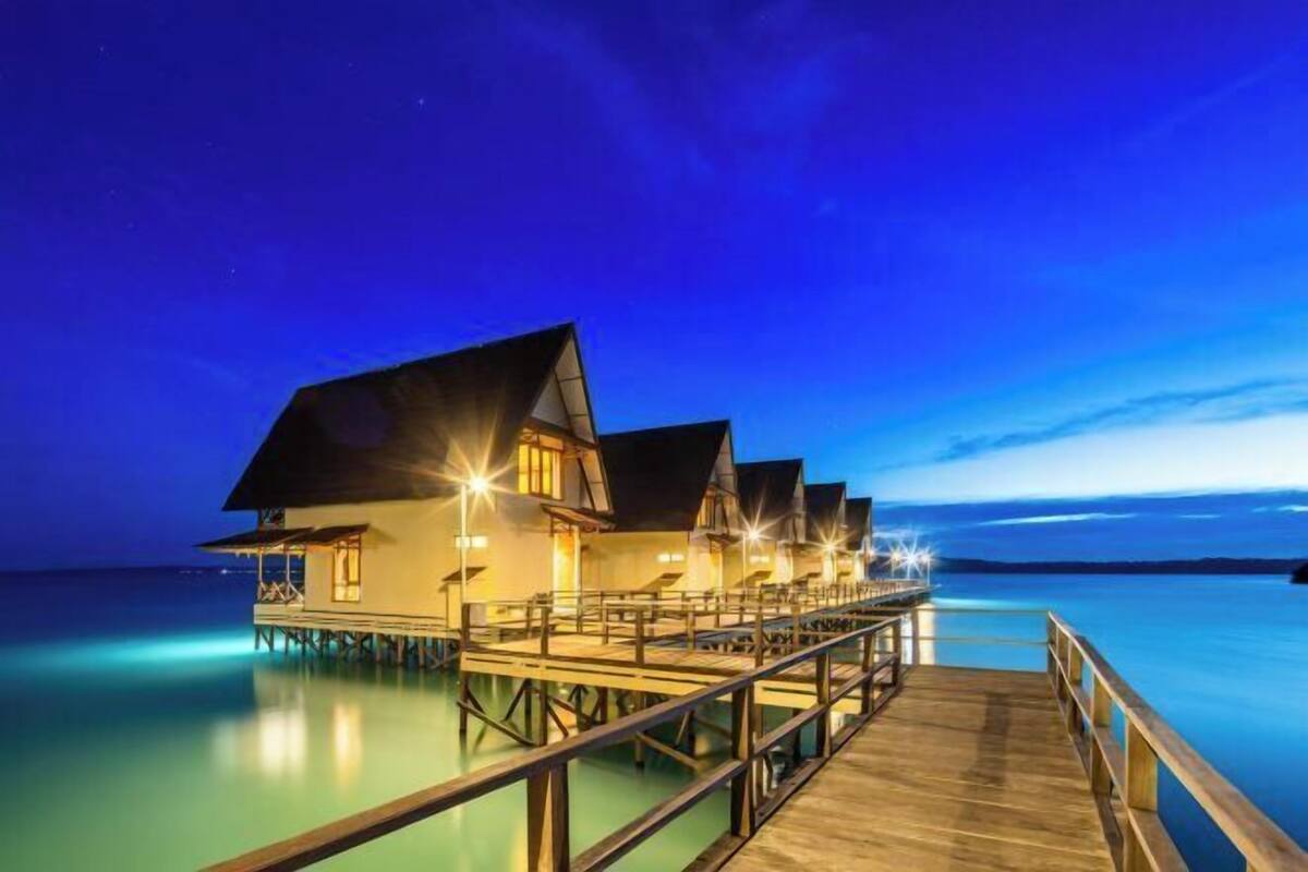 Overwater bungalows connected by a wooden deck.