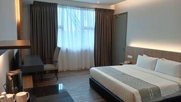 A modern hotel room with a large bed, a desk, and a chair.