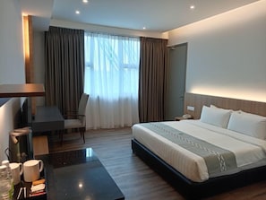 A modern hotel room with a large bed, a desk, and a chair. - 56 Hotel Block B (Kuching)