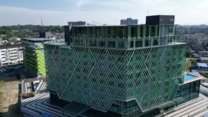 Um edifício moderno com fachada geométrica singular, vários andares e telhado plano.
