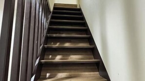 A staircase with dark wooden steps and a handrail on the left. - Osaka Nimi family house direct KIX airport (Osaka)