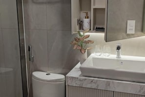 A modern bathroom with a white sink, a toilet, and a shower enclosure. - Ben Thanh Luxury Suite Hotel (Ho Chi Minh City)