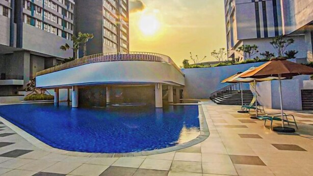 A modern building with a swimming pool, a covered area, and a staircase leading to an upper level. - Double Storey Pool at Trio Setia Klang by HCK (Port Klang)
