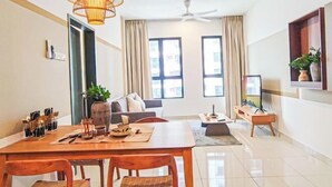 A modern living room with a sofa, a dining table with chairs, a ceiling fan, and large windows. - Double Storey Pool at Trio Setia Klang by HCK (Port Klang)