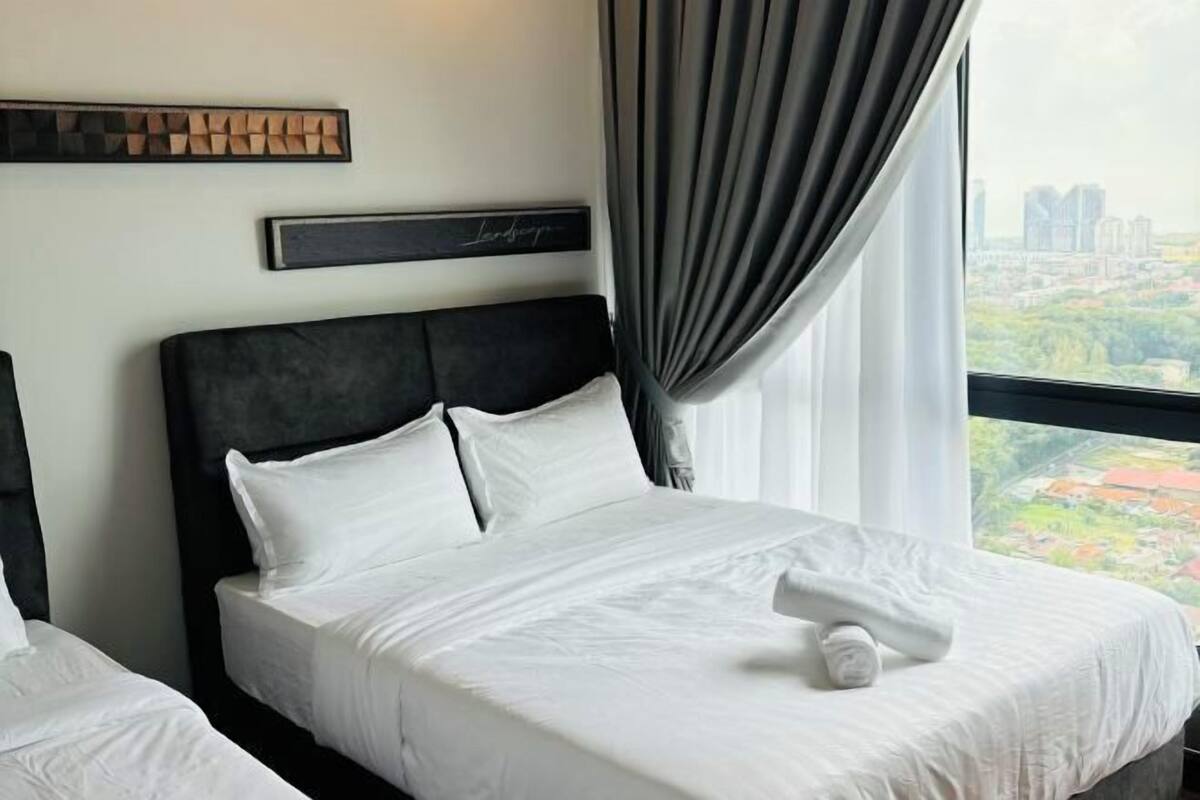 Ein Hotelzimmer mit einem großen Bett, einem Kopfteil, Blick auf die Stadt und einem Wandbild.