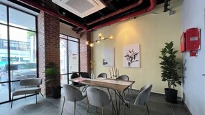 A conference room with a brick wall, large windows, and a table with chairs. - Kingston Hotel 7 @ Johor Bharu (Johor Bahru)