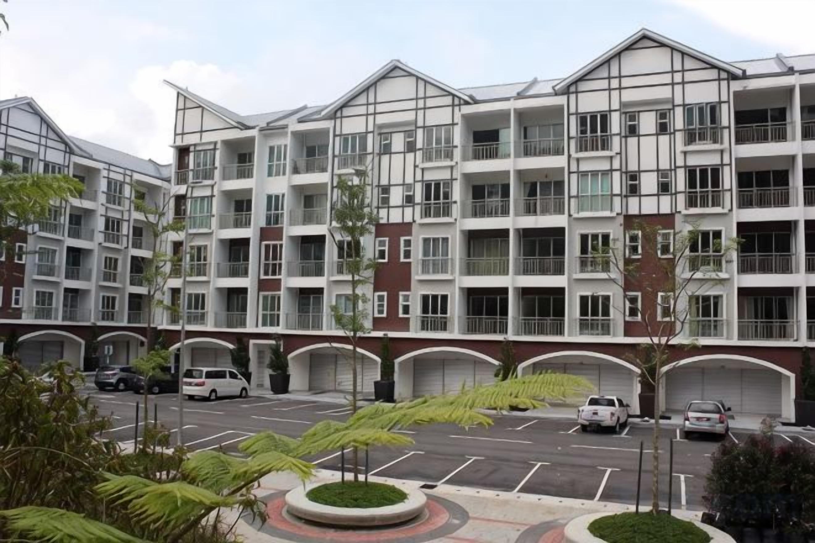 A multi-story residential building with a parking lot in front.