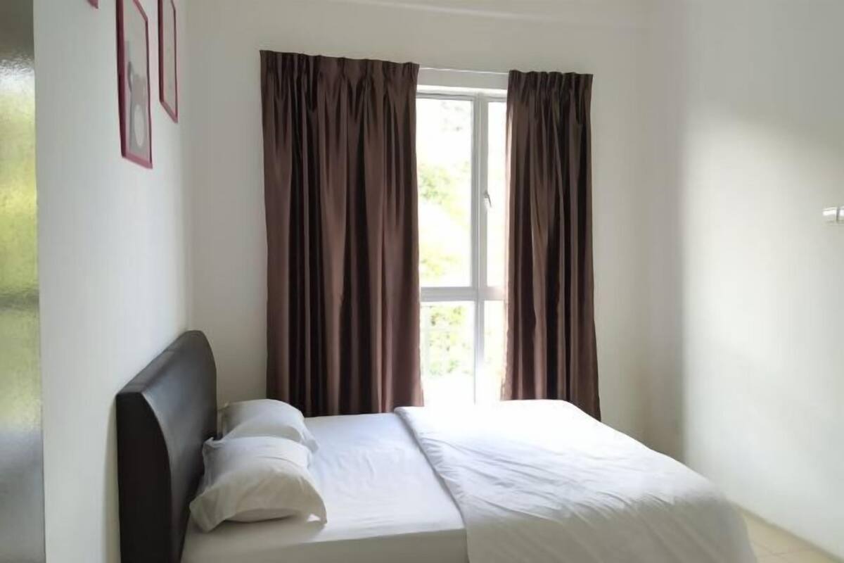 A bedroom with a bed, curtains, and a window.