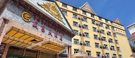 A hotel with a prominent entrance, multiple floors, and a traditional architectural design.