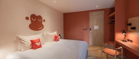 Una habitación de hotel con una cama, un escritorio y una silla.