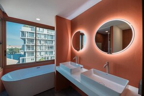 A modern bathroom with a freestanding bathtub, two sinks, and a large mirror. - BLU Monkey Hub & Hotel Bangsaen (Chonburi)