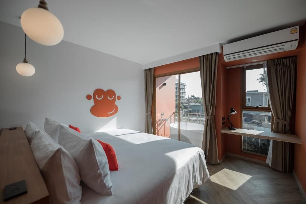 Habitación de hotel con cama, escritorio, aire acondicionado y vistas al exterior.