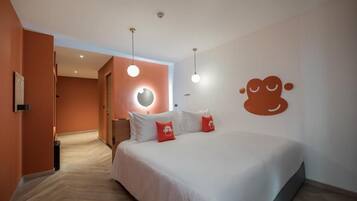Habitación de hotel con cama, lámpara circular y un adorno de pared.