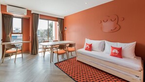 Une pièce comprenant un canapé, une table à manger, des chaises et un tapis à motifs.