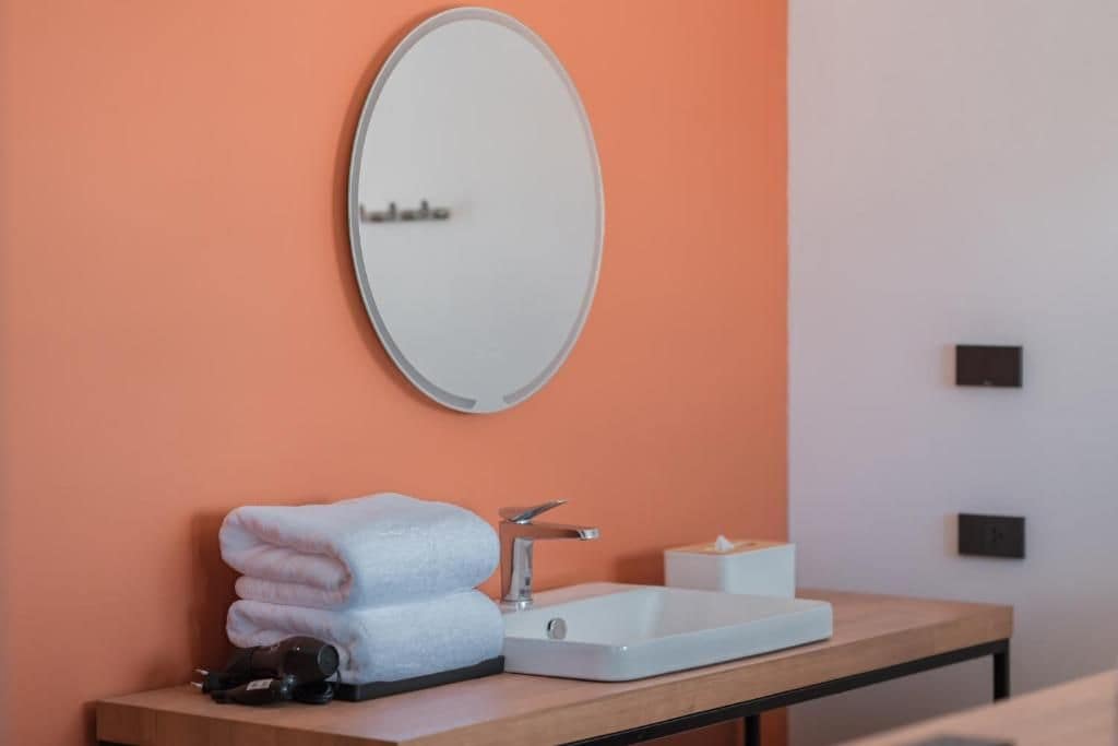 Un baño con lavabo, espejo y toallas.