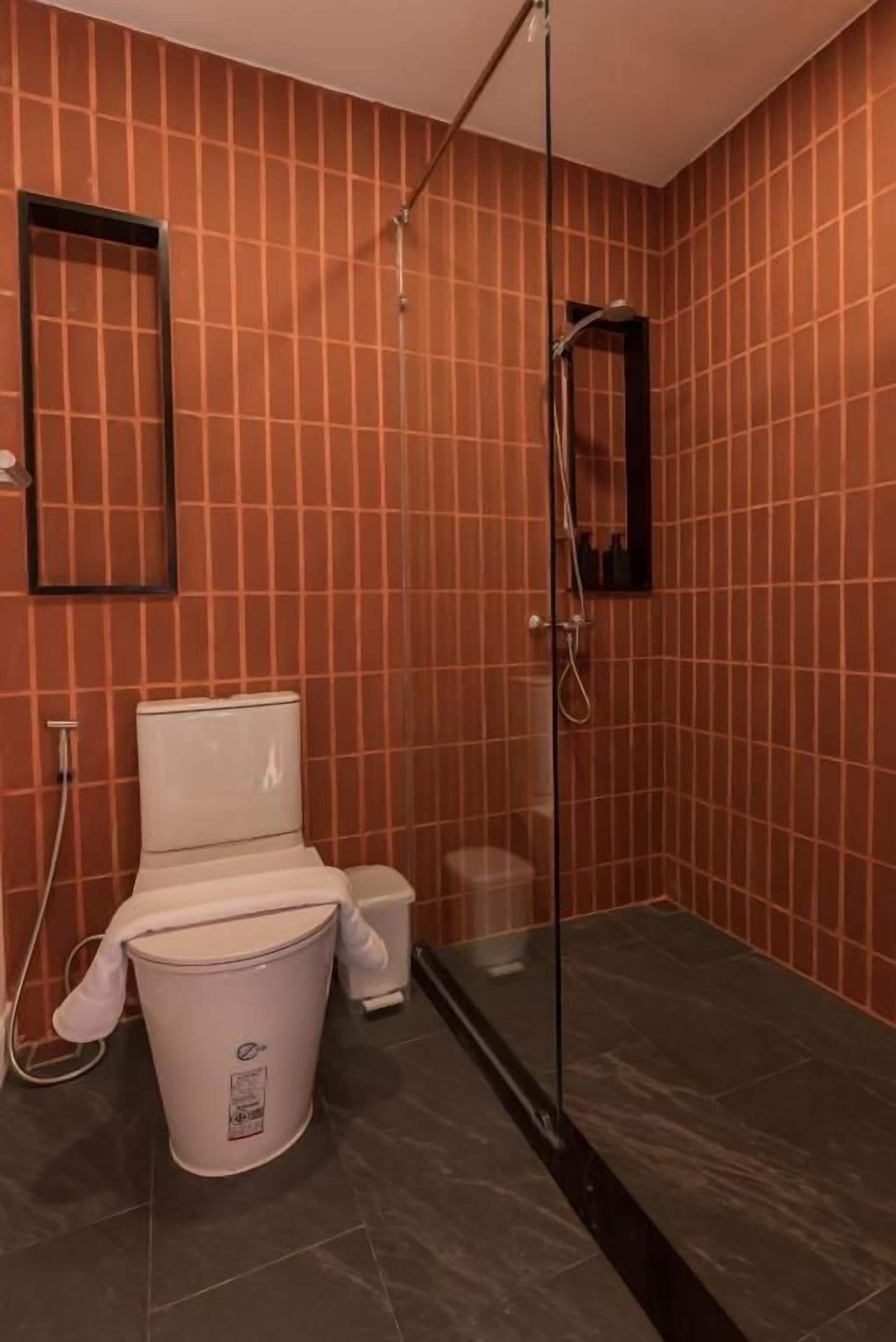 Un baño con inodoro, bidé y cabina de ducha de vidrio.